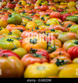 Heirloom tomatoes at the Farmers Market in a square crop appearing like the tomatos go on and on forever Stock Photo