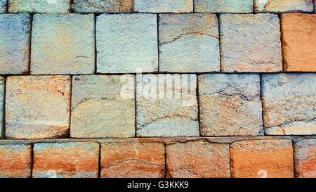 a brick wall made from concrete with orange and blue colors Stock Photo
