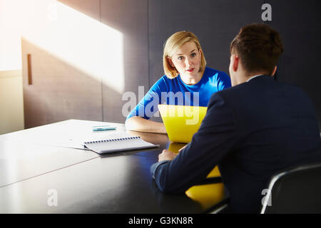 Colleagues sitting at desk having meeting Stock Photo