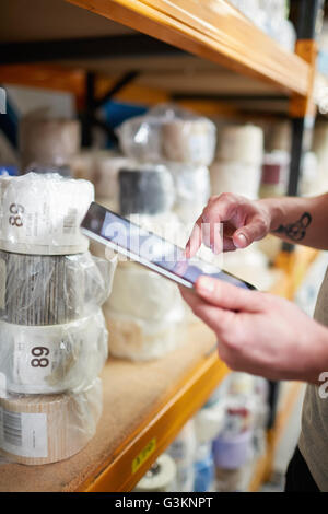 Close up of worker stock taking using digital tablet touchscreen  in roller blind factory Stock Photo