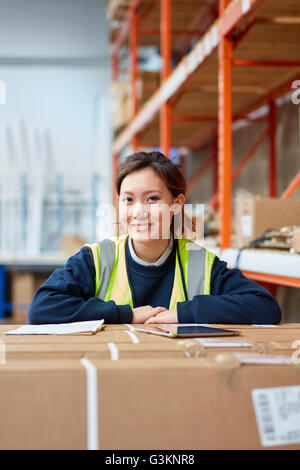 Portrait of female factory worker in factory warehouse Stock Photo