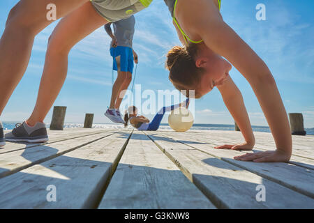 Friends on pier using exercise equipment Stock Photo