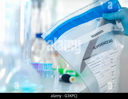 Forensic scientist preparing a knife taken from a scene of crime for DNA analysis Stock Photo