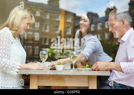 Waitress serving lunch to mature dating couple at restaurant table, London, UK Stock Photo