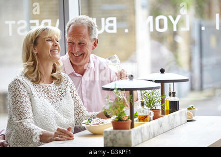 Mature dating couple laughing at restaurant lunch, London, UK Stock Photo