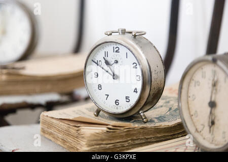 Alarm clock on weathered books Stock Photo