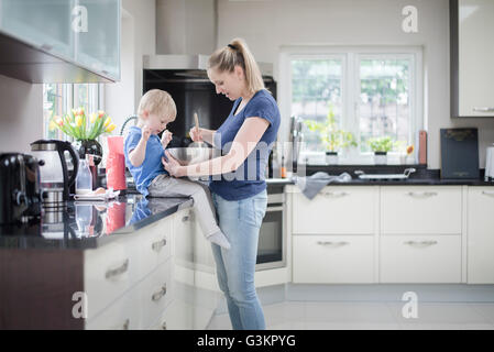 Mother and son baking together, stirring mixture in mixing bowl Stock Photo