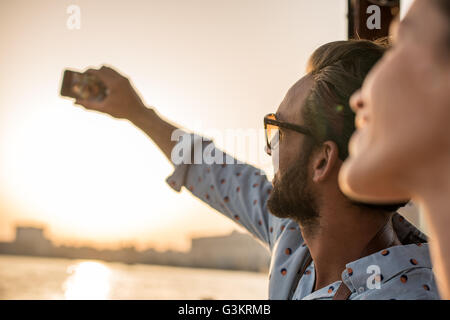Close up of romantic couple taking smartphone selfie at Dubai marina, United Arab Emirates Stock Photo