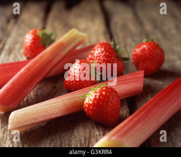 Strawberries and rhubarb on wooden table, close-up Stock Photo