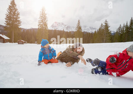 Young man and sons having snowball fight in winter, Elmau, Bavaria, Germany Stock Photo