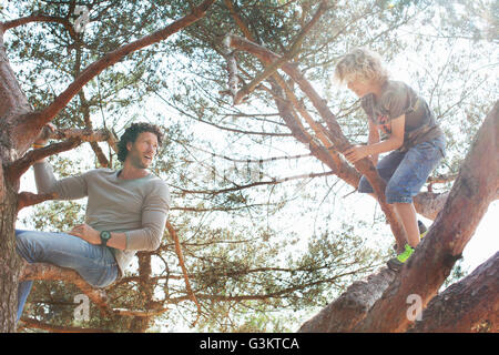 Father and son climbing tree Stock Photo