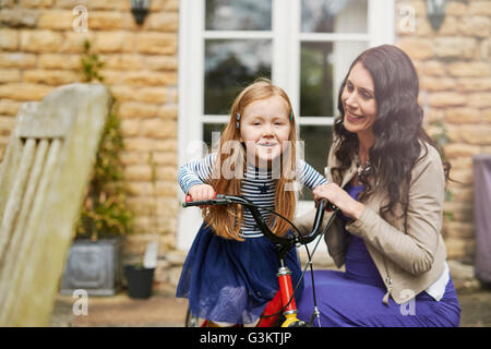 Mother teaching daughter to rise bicycle Stock Photo