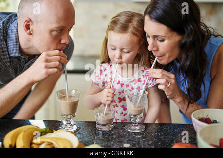 Family drinking smoothie with straws Stock Photo