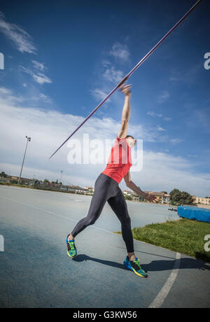 Young man throwing javelin in sports ground Stock Photo