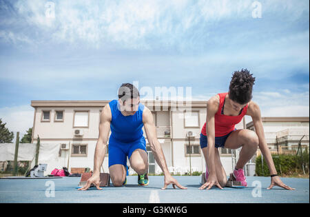 Young male and female sprinters training on running track Stock Photo