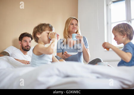 Boys having breakfast in parents bed Stock Photo