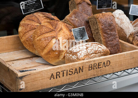 A wooden tray full of artisan bread for sale in the UK Stock Photo