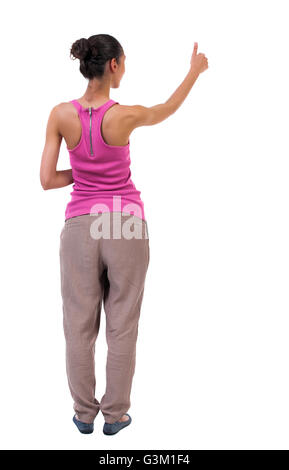 Back view of curly woman thumbs up. Rear view people collection. backside view of person. Isolated over white background. slender blonde in a jeans shows the symbol of success or hitchhiking Stock Photo
