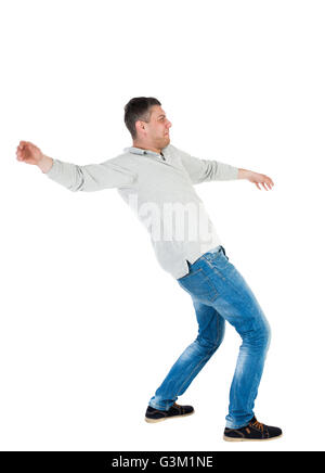 Back view man Balances waving his arms. Rear view people collection. backside view of person. Isolated over white background. A guy in a gray jacket at the time of the fall. Stock Photo