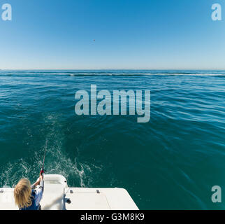 Boy fishing on sailboat Stock Photo