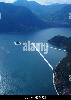 Iseo Lake, Italy. 12th June, 2016. Aerial view of Christo's 'The Floating piers' project are now completed but not yet accessed by people. The piers are made up of floating polyethylene cubes and covered with fabric creating the walkways. The small isola di San Paolo is completely surrounded. Riccardo Mottola/Alamy Live News Stock Photo