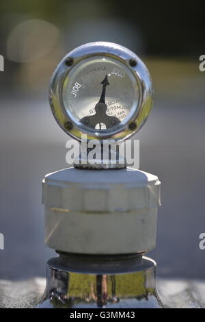 Westbury, New York, USA. June 12, 2016.  Wilmot-Breeden car radiator cap Calormeter temperature gauge with transparent dial, seen in close up on hood of vintage car, is at the Antique and Collectible Auto Show at the 50th Annual Spring Meet at Old Westbury Gardens, in the Gold Coast of Long Island, and sponsored by Greater New York Region, GNYR, Antique Automobile Club of America, AACA. Stock Photo