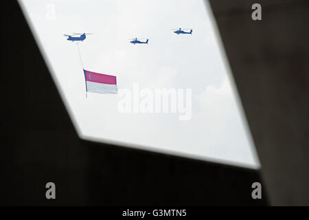 Singapore. 14th June, 2016. A Republic of Singapore Air Force (RSAF) CH-47 Chinook helicopter hanging the Singapore national flag flies in formation with two RSAF AH-64 Apache helicopters during a practice for national day celebrations in the southern sky of Singapore on June 14, 2016. Singapore will celebrate the national day on August 9. Credit:  Then Chih Wey/Xinhua/Alamy Live News Stock Photo