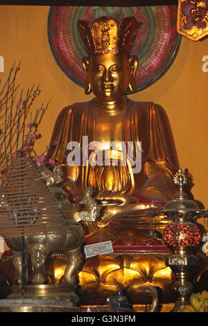 Buddha in a Vietnamese temple with offerings including flowers and the ...