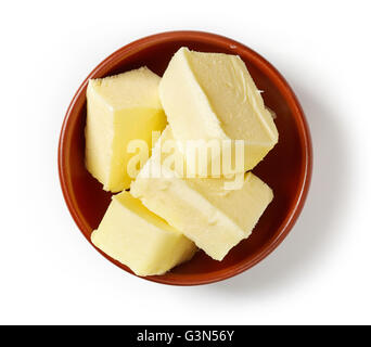 Butter pieces in clay bowl isolated on white background, top view Stock Photo