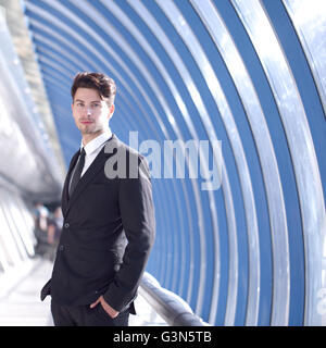 Young Businessman standing in corridor of modern office building Stock Photo