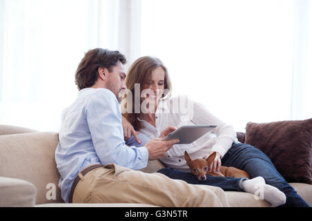 Cheerful couple using digital tablet at home Stock Photo
