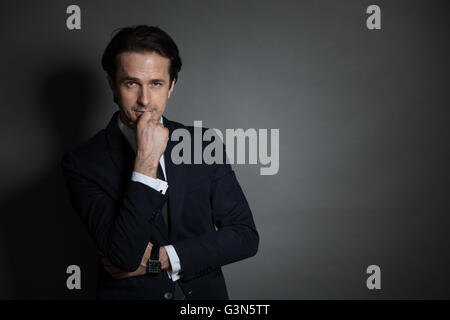 Portrait of businessman in suit on dark background Stock Photo