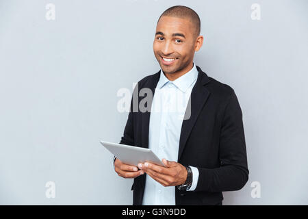 Happy african american young man smiling and using tablet Stock Photo