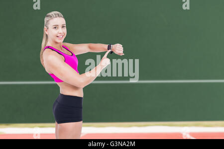 Composite image of female athlete using her smart watch Stock Photo