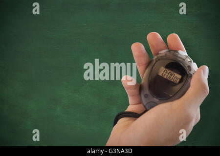 Close up of coach is holding a stopwatch  against green chalkboard Stock Photo