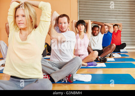 People stretching during fitness class in fitness center Stock Photo