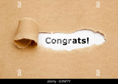 The text Congrats appearing behind torn brown paper. Stock Photo