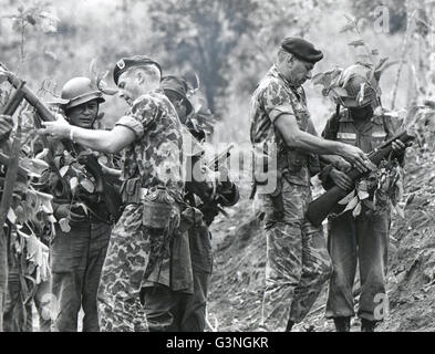 US Green Beret troops train Vietnamese - Instruction in marksmanship with live ammunition is given South Vietnamese native troops by Sgt. Stanley Harold, left, and Capt Robert Lopez of the US Special Forces. Because of the rapid increase of the size of this corps, officers now are assigned on a 'non-volunteer' basis, but enlisted men are all still volunteers. Stock Photo