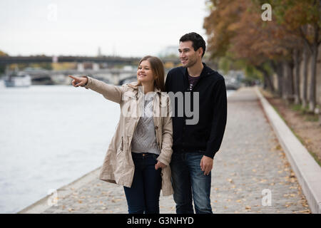 young couple man and woman standing on the riverside of Seine, Paris, France Stock Photo