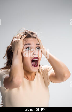 Portrait of young woman with shocked facial expression Stock Photo