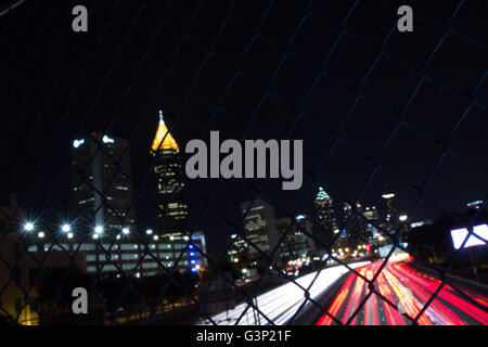 Downtown Atlanta as viewed from above the Downtown Connector with a chain link fence between the camera and skyline Stock Photo