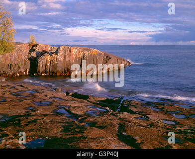 USA, Minnesota, Lichen-covered rocks and stormy sky over Lake Superior at Artist Point, near Grand Marais. Stock Photo