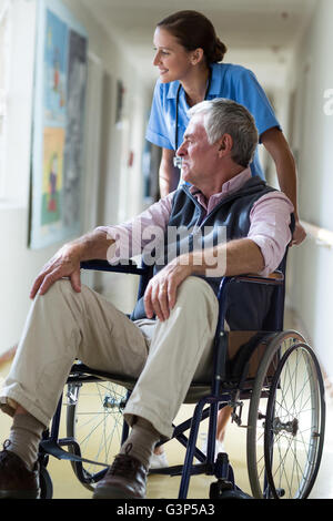 Smiling female doctor and senior man looking through window Stock Photo