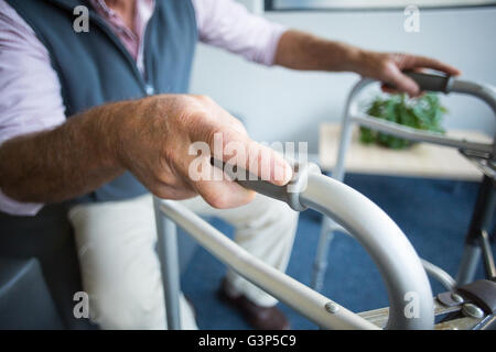 Senior man trying to stand with the help of walking frame Stock Photo