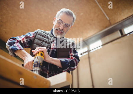 Carpenter drilling a plank of wood Stock Photo