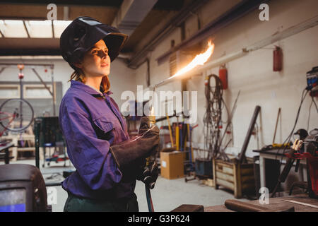 Young woman welder with a flaming torch Stock Photo