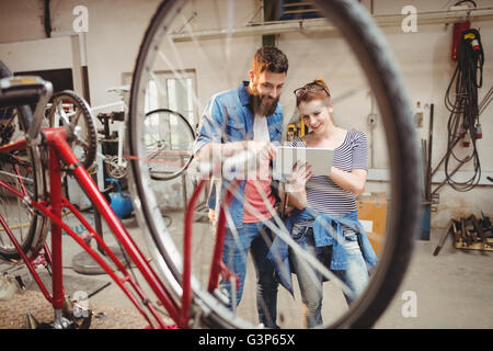 Bicycle repairer colleagues looking at laptop Stock Photo