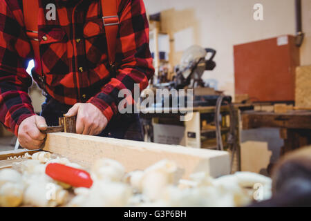 Carpenter working on wood plank Stock Photo
