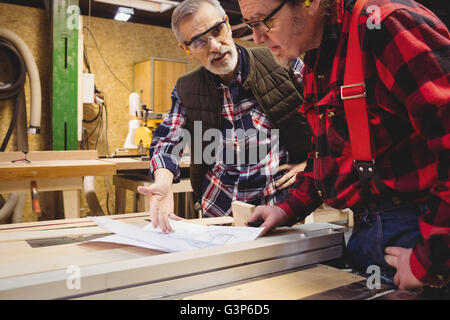 Duo of carpenter working on a wood plank Stock Photo