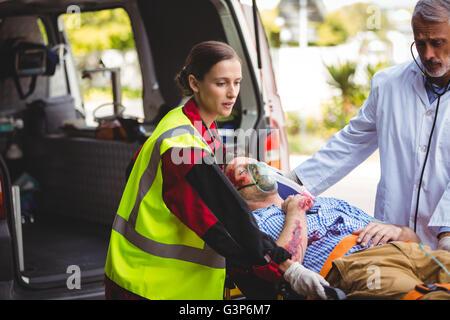 Ambulance crew taking care of an injured person Stock Photo - Alamy